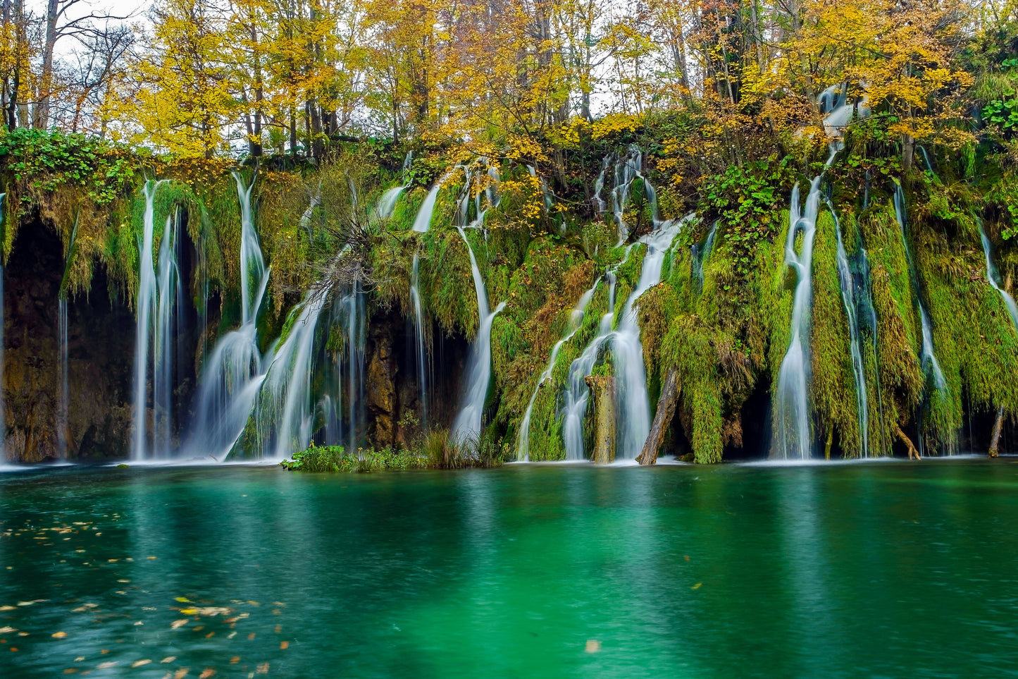 Tablou canvas cu cascade peste mușchi verde și lac turcoaz